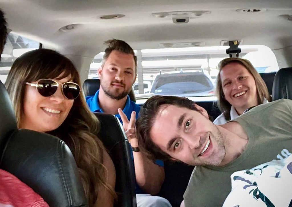 4 people in the back of an SUV