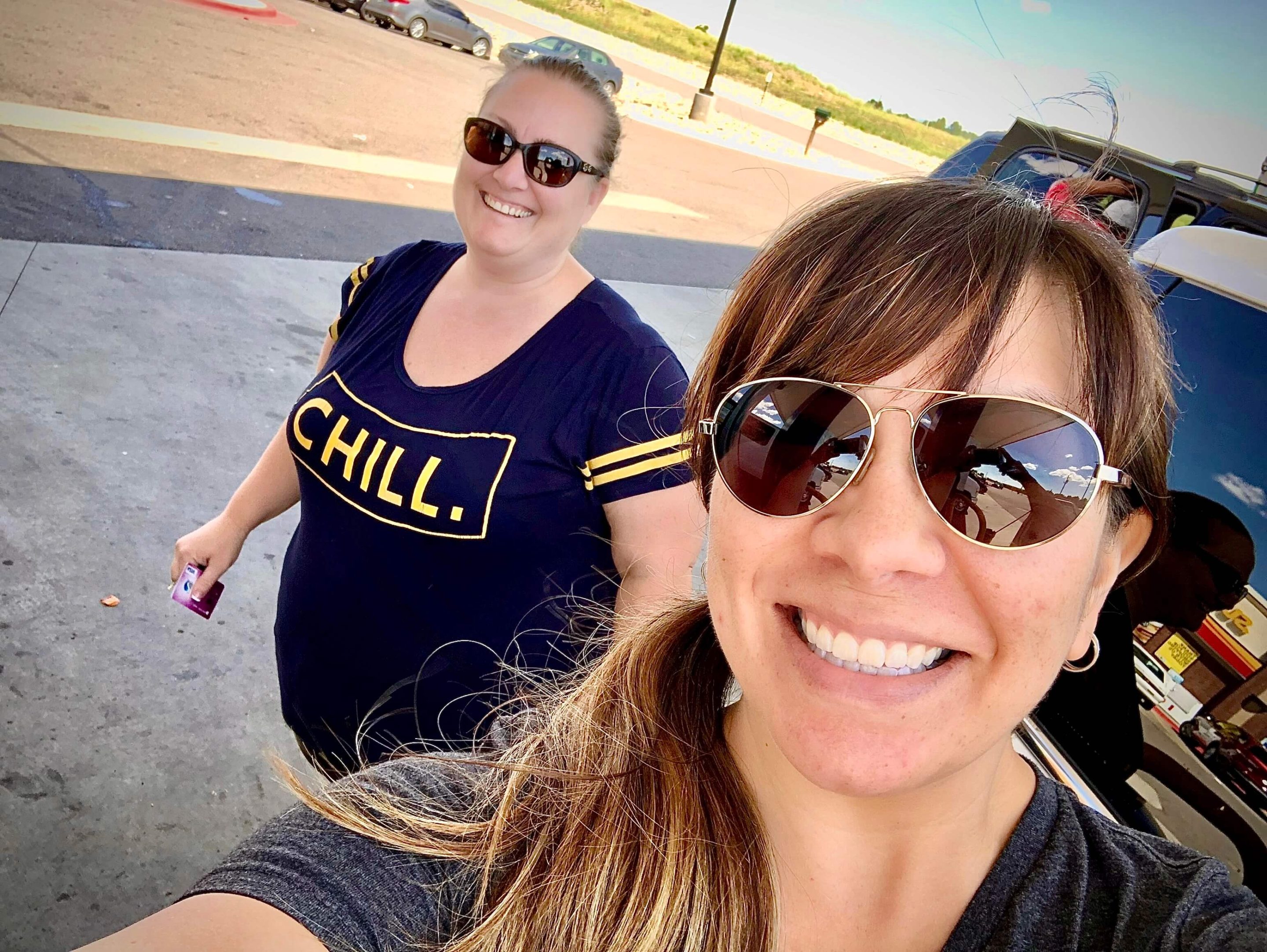 two women taking an usie at a gas station