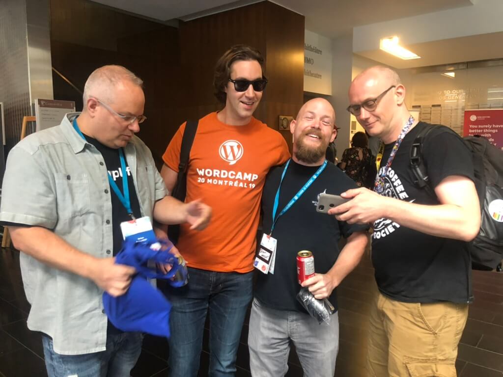group of four men at a conference